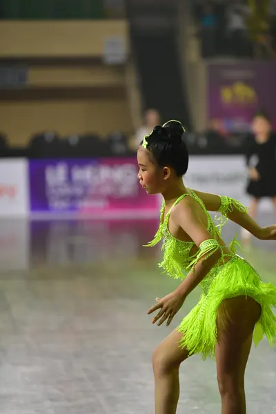 Dancesport competitor: Female dancer: lime green Latin dance dress with fringe on the skirt and sleeves