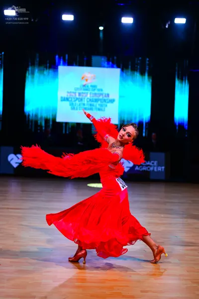 Dancesport competitor: Female dancer: red latin dress with large, voluminous red feather or fringe-like
