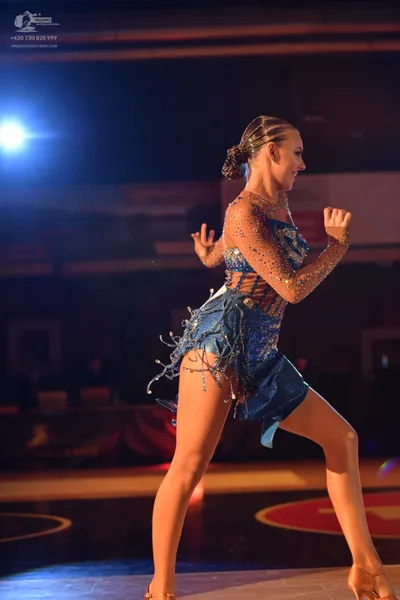 Dancesport competitor: Female dancer: blue latin dress with sequins and beaded strands hanging from the