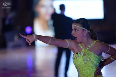 Dancesport competitor: Female dancer: lime green Latin dance costume heavily embellished with rhineston
