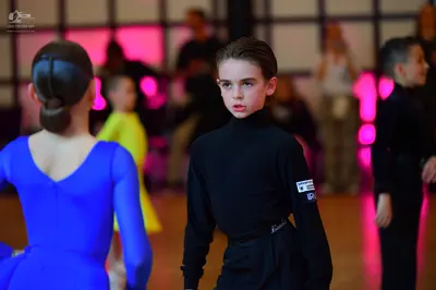 Dancesport competitor: Dancer in blue: blue long-sleeved Latin dress in smooth fabric