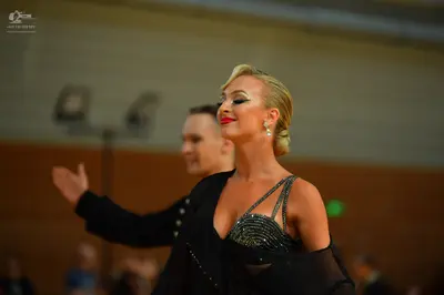 Dancesport competitor: Female dancer: black sequined Latin-style top with thin straps and a black sheer