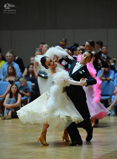 Dancesport competitor: Female dancer: white ballroom dress with a voluminous, layered ruffled skirt and