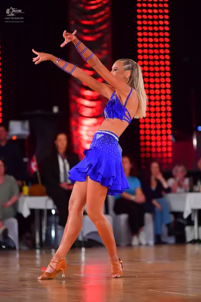 Dancesport competitor: Female dancer: blue two-piece latin costume with sequin embellishments on the to