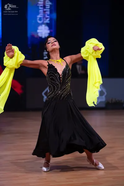 Dancesport competitor: Female dancer: black ballroom dress with a sequined bodice and large, voluminous