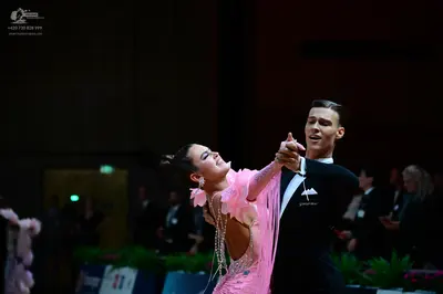 Dancesport competitor: Female dancer: pink latin dress with floral-like fabric embellishments and intri
