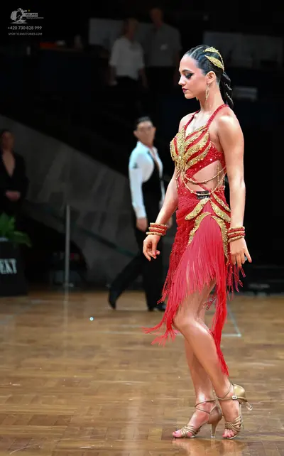 Dancesport competitor: Female dancer: red latin dress with gold sequin embellishments and fringe, gold 
