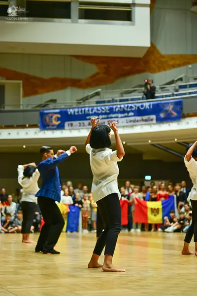 Dancesport competitor: Dancer in blue: blue long-sleeved button-up shirt and black pants