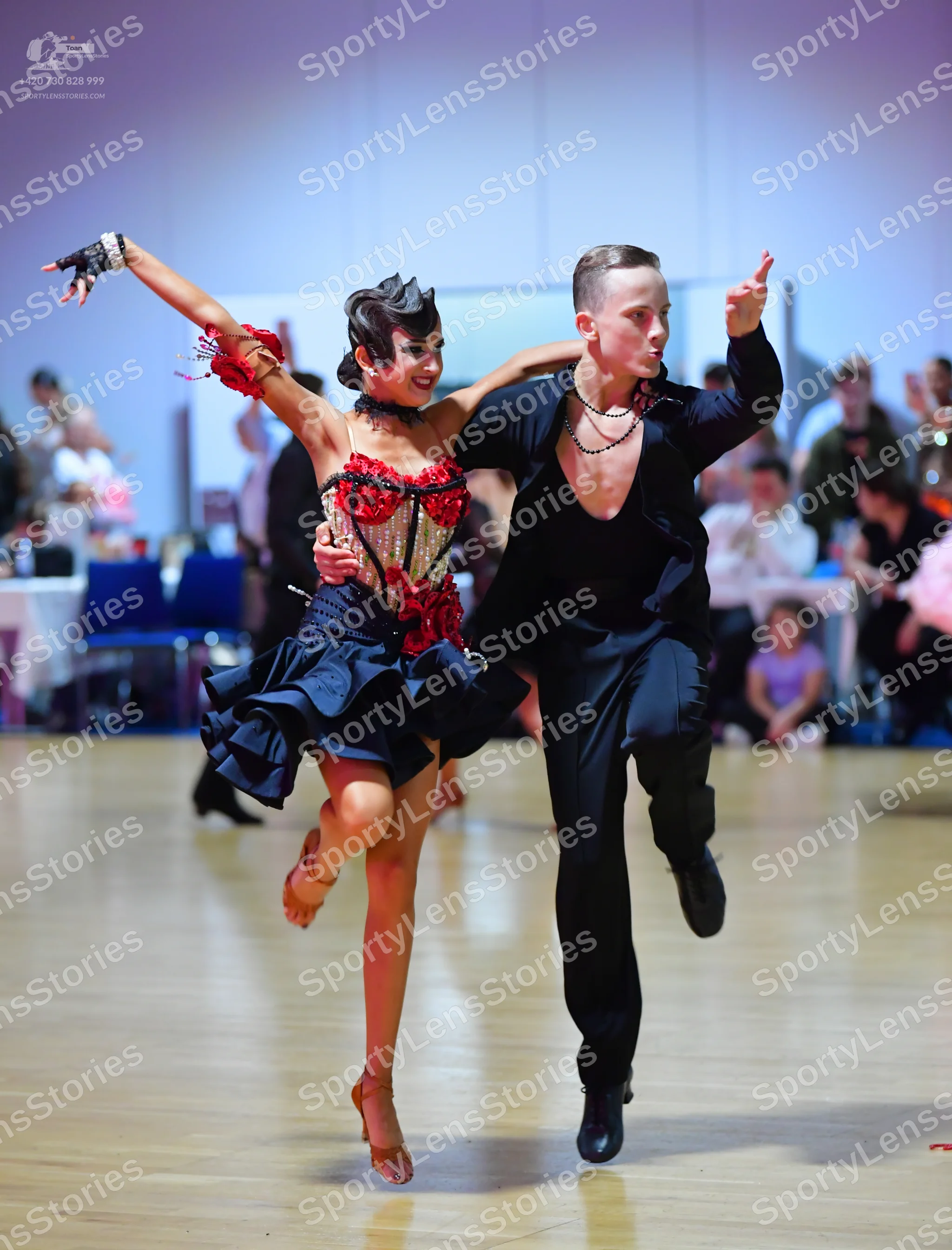Dancesport competitor: Male dancer: black long-sleeve shirt, black trousers, and a silver chain necklac