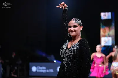 Dancesport competitor: Female dancer: black long-sleeved dress with silver sequins and intricate silver