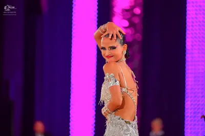 Dancesport competitor: Female dancer: silver/white Latin dance dress heavily embellished with sequins a