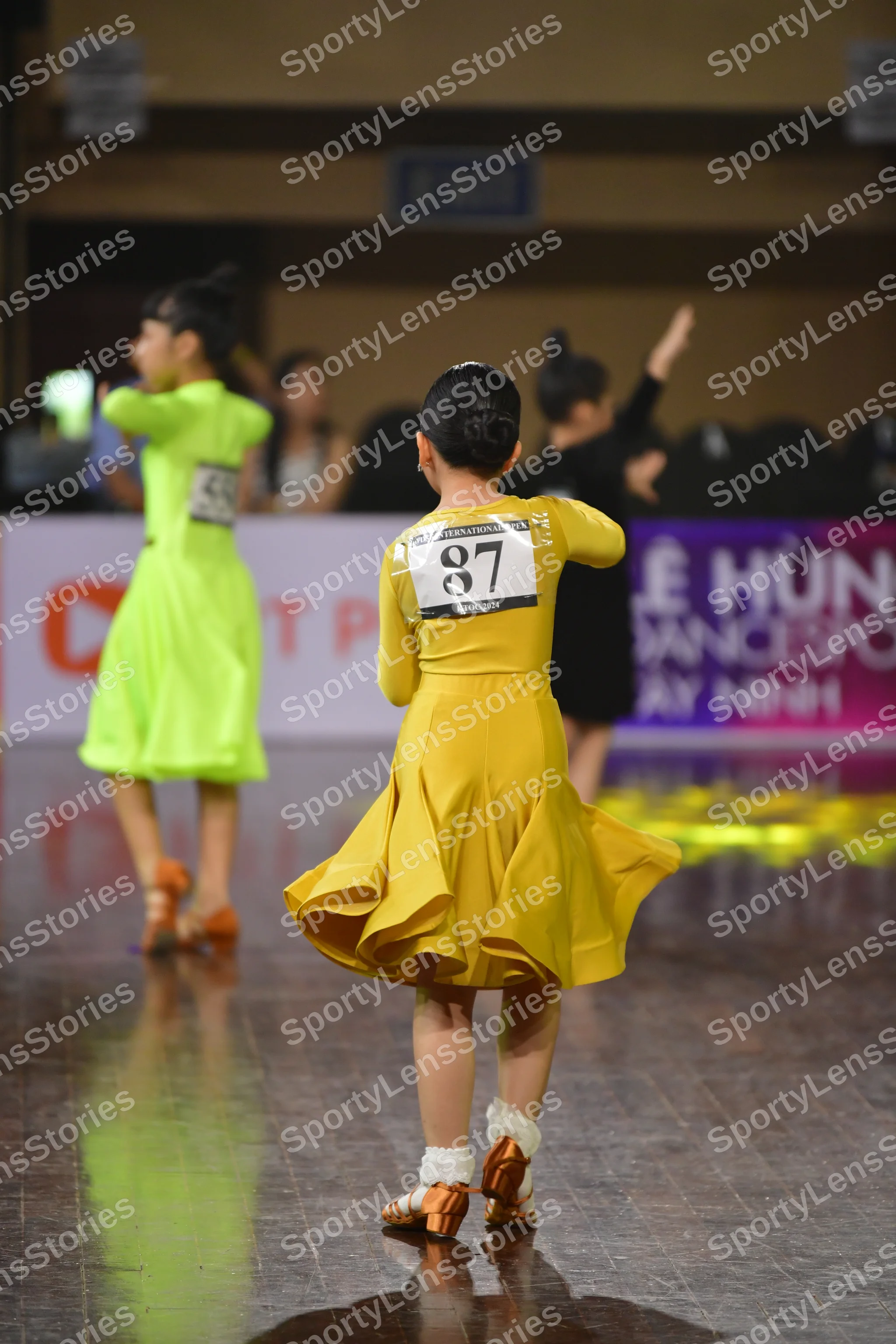 Dancesport competitor #87, #146: Female dancer 1: bright yellow Latin dress with a short, flared skirt