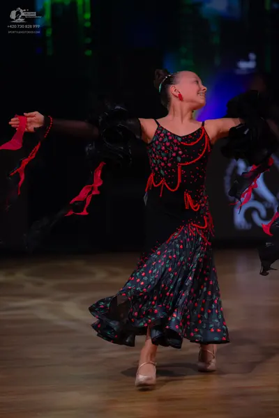 Dancesport competitor: Female dancer: black Latin dress with a red pattern, featuring thin straps, red 