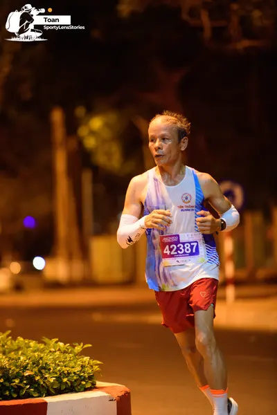 Marathon runner #42387: Runner 1: light blue and white patterned tank top, maroon shorts, white arm slee