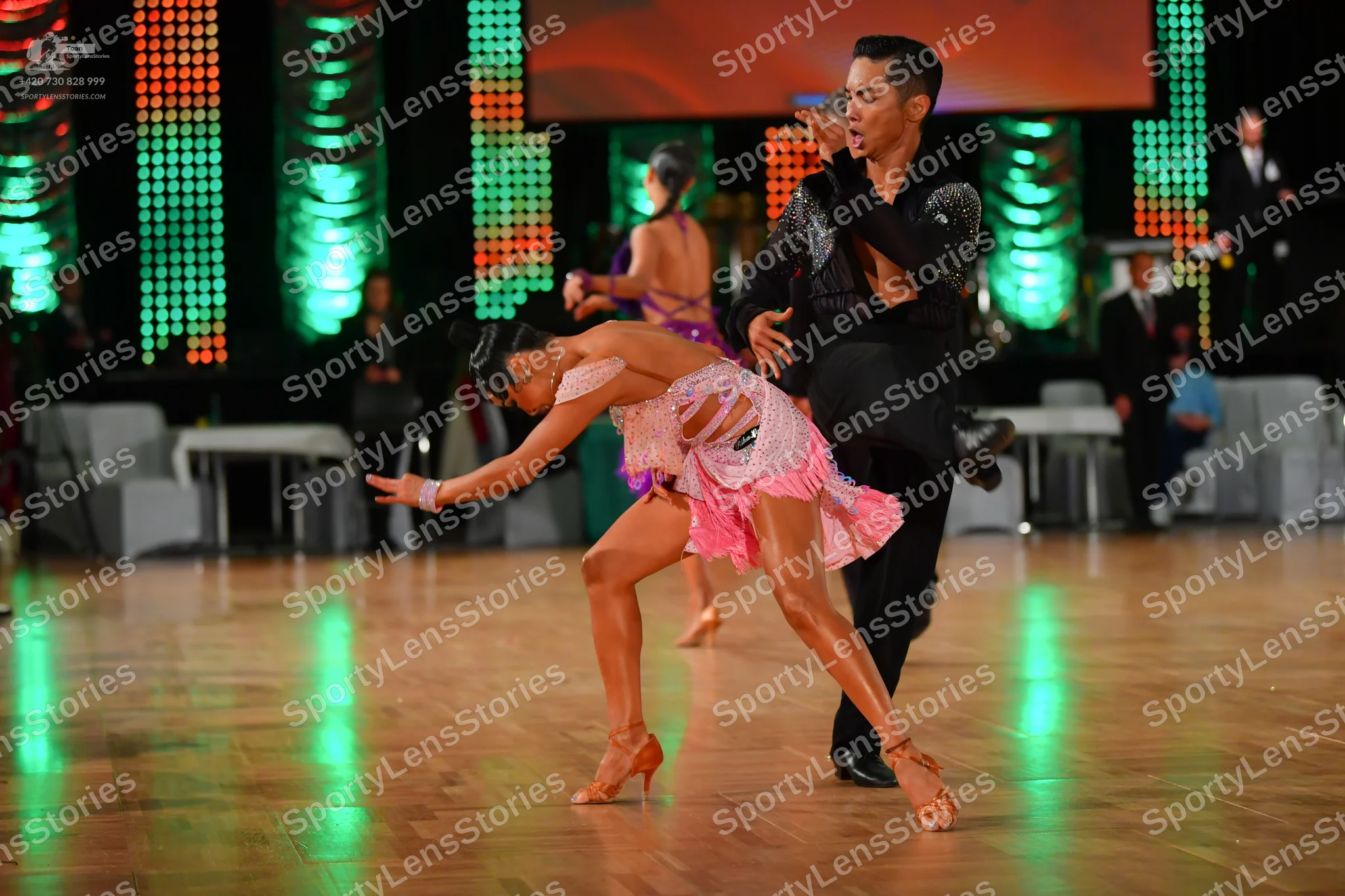 Dancesport competitor: Male dancer: black dance suit with a shimmering, possibly sequined, jacket and b