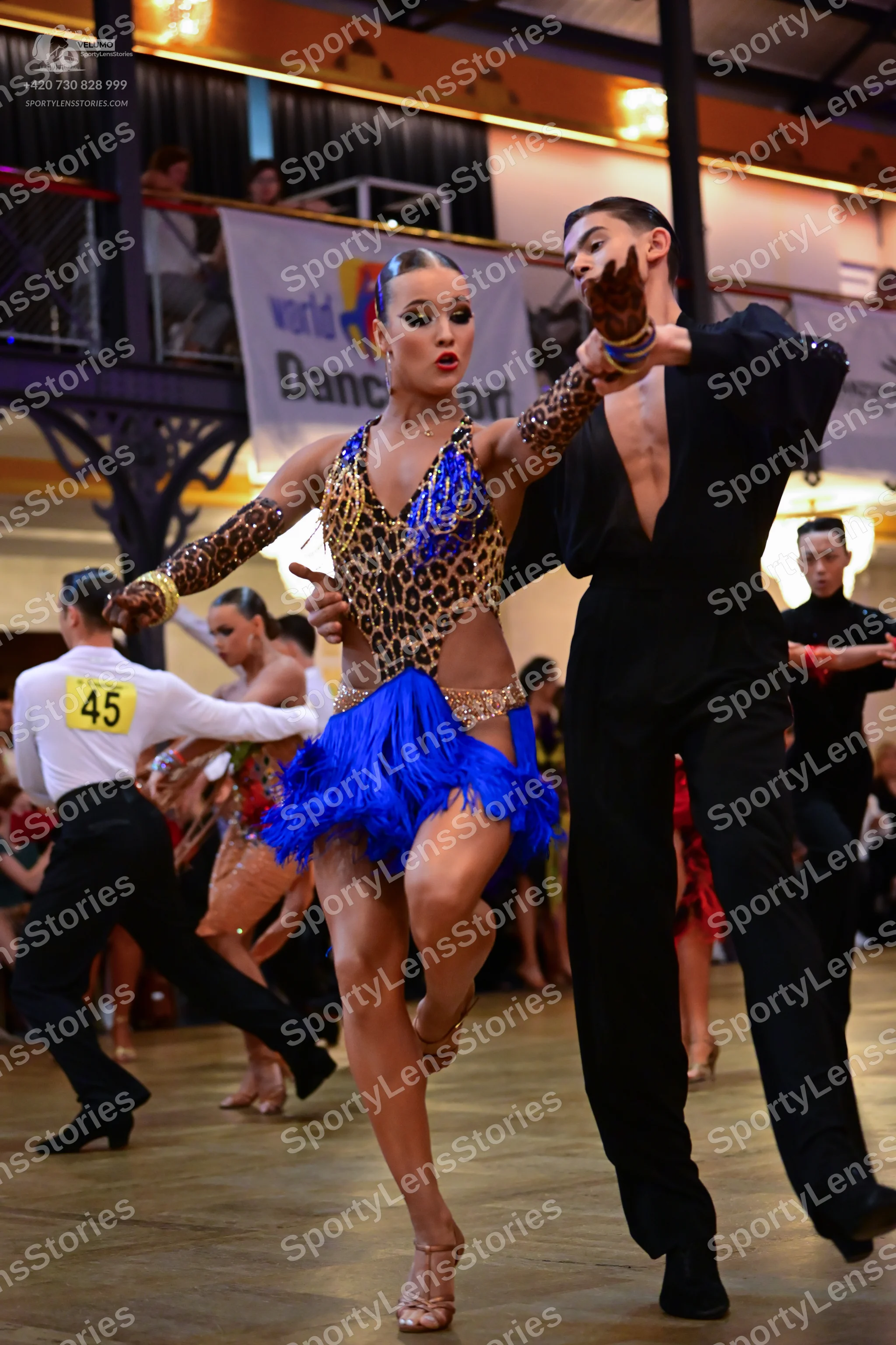 Dancesport competitor #45: Female dancer: leopard print Latin dress with a blue fringed skirt and gold sequ