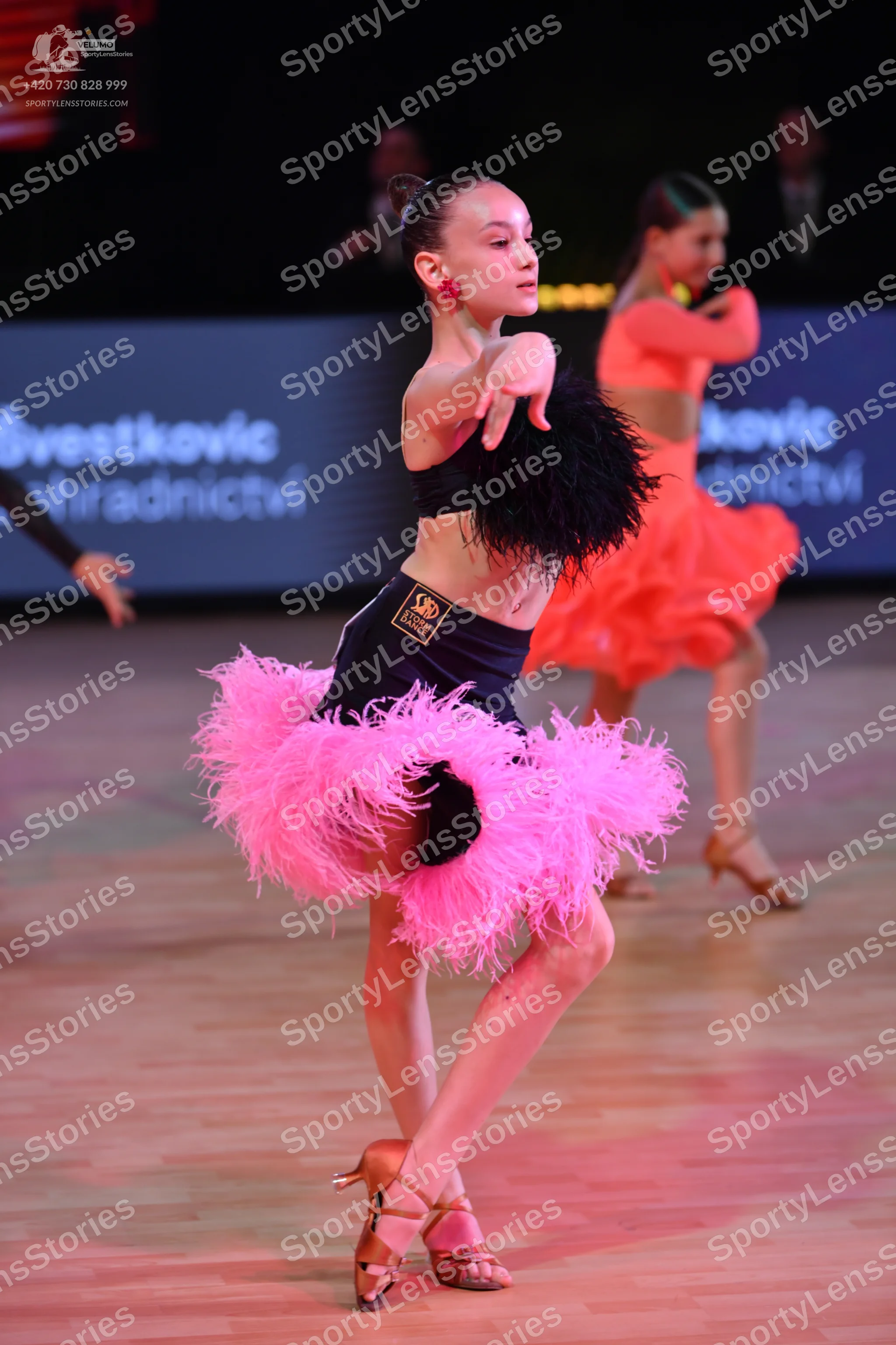 Dancesport competitor: Main dancer: black crop top with black fringe and a black skirt with voluminous