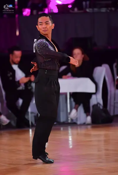 Dancesport competitor: Male dancer: black long-sleeved shirt with sequin embellishments on the upper po
