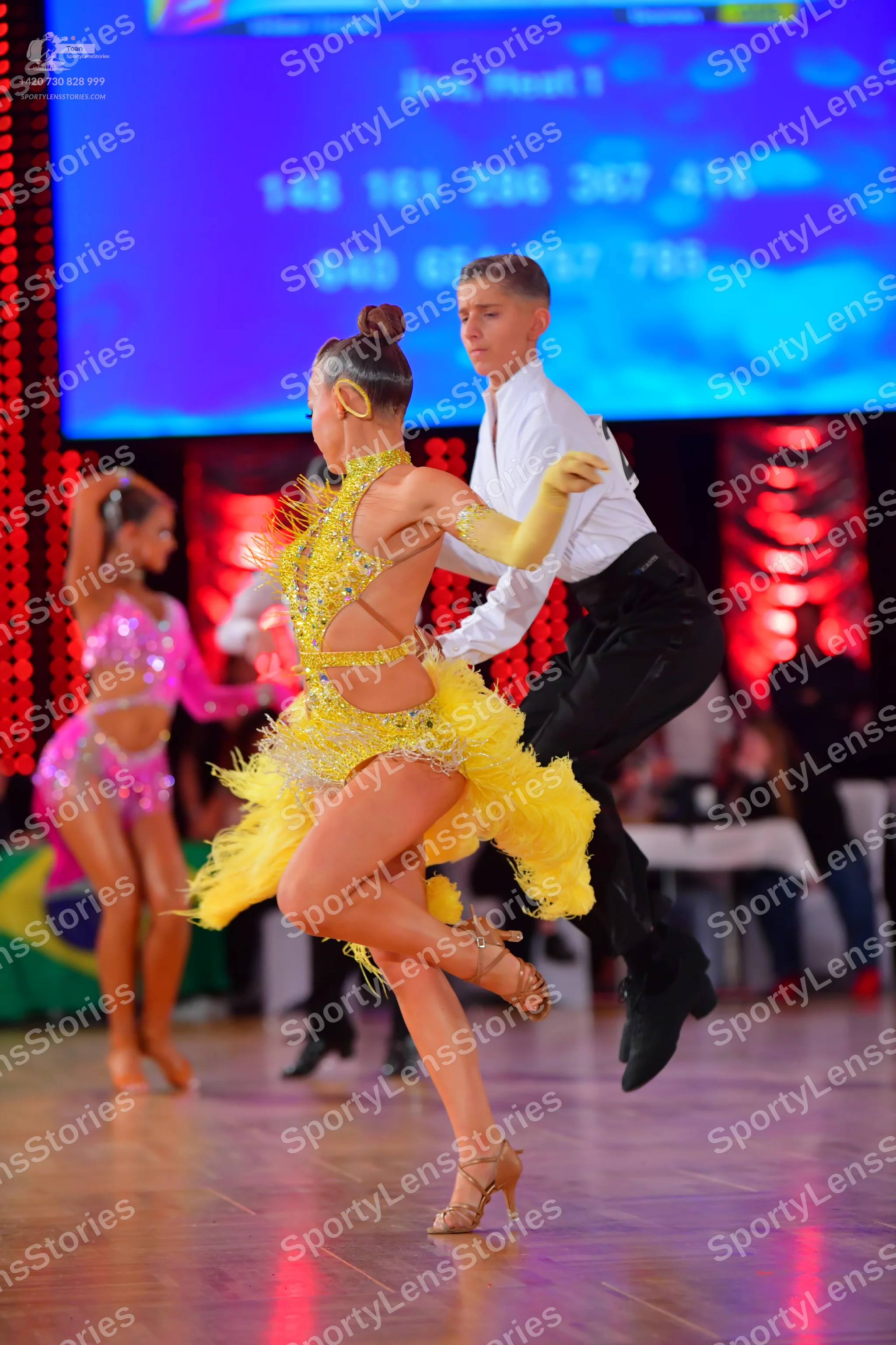 Dancesport competitor: Female dancer: yellow Latin dress with fringe and sequins