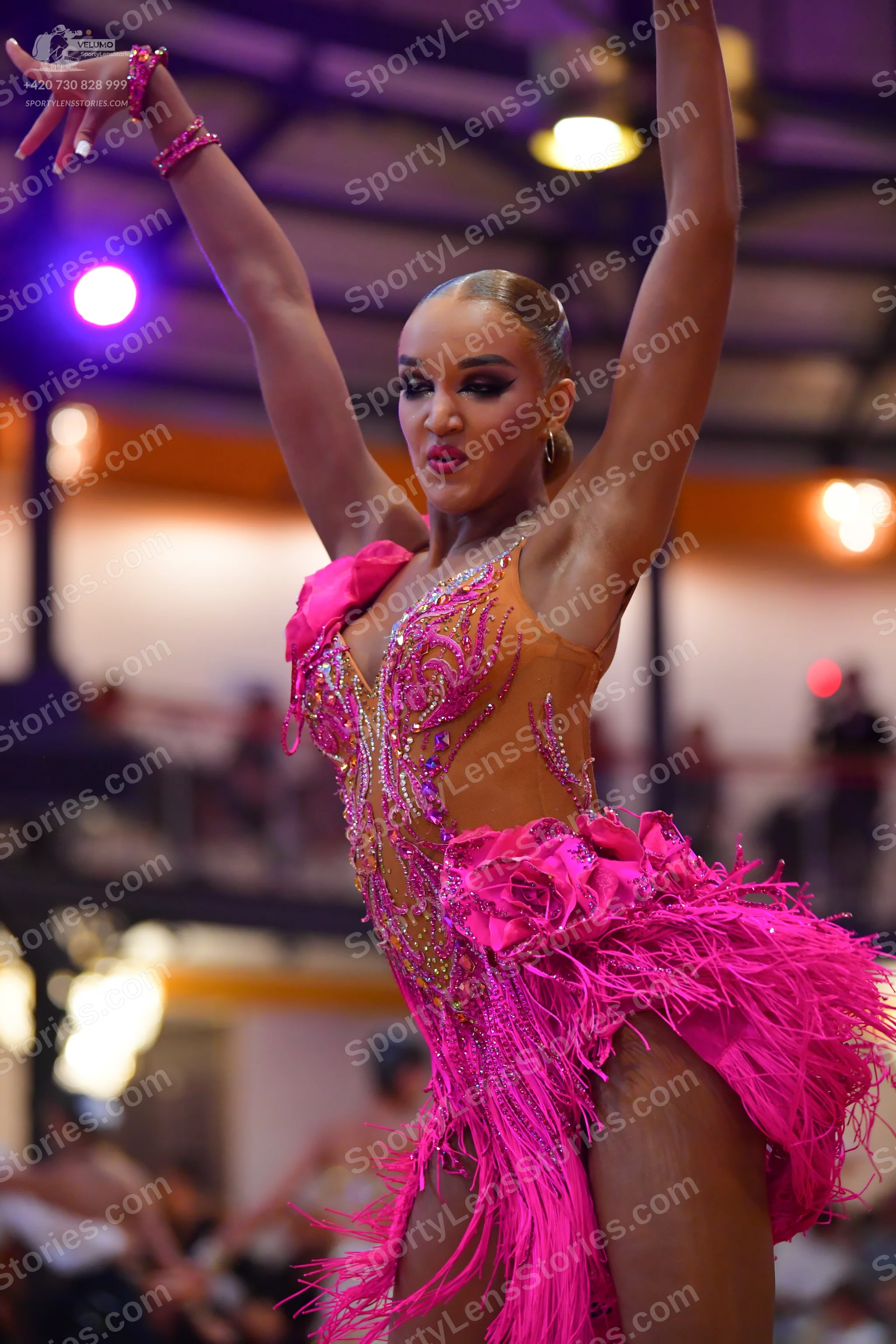 Dancesport competitor: Female dancer: bright pink latin dress with nude-colored mesh, pink sequins, lar