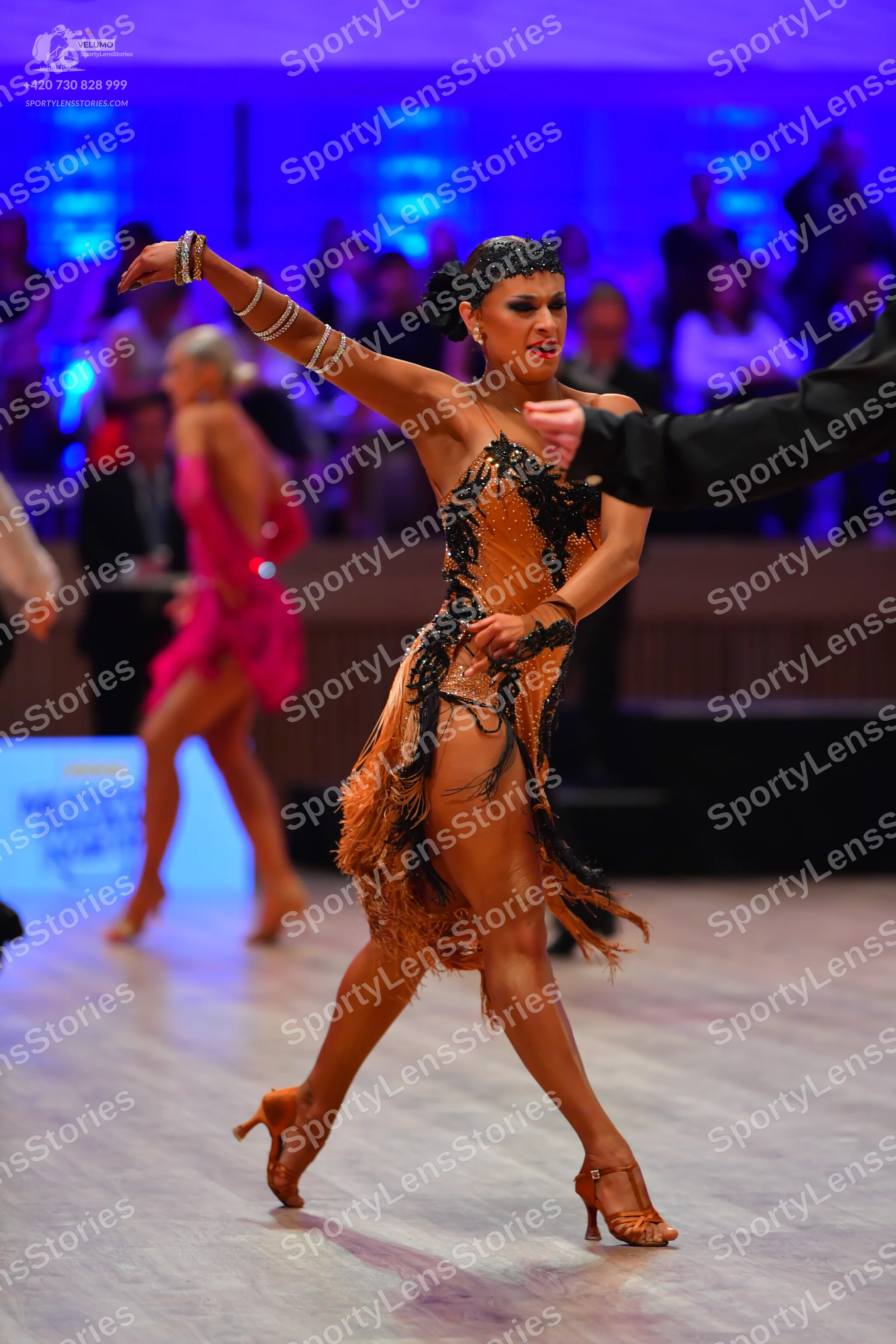 Dancesport competitor: Main female dancer: orange Latin dress with black lace/sequin detailing and frin