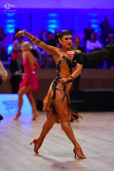 Dancesport competitor: Main female dancer: orange Latin dress with black lace/sequin detailing and frin