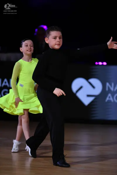 Dancesport competitor: Female dancer: bright lime green long-sleeved dress with a flared skirt