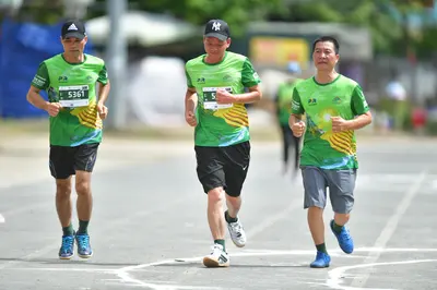 Marathon runner #5361: Runner 1: green jersey, black shorts, blue shoes