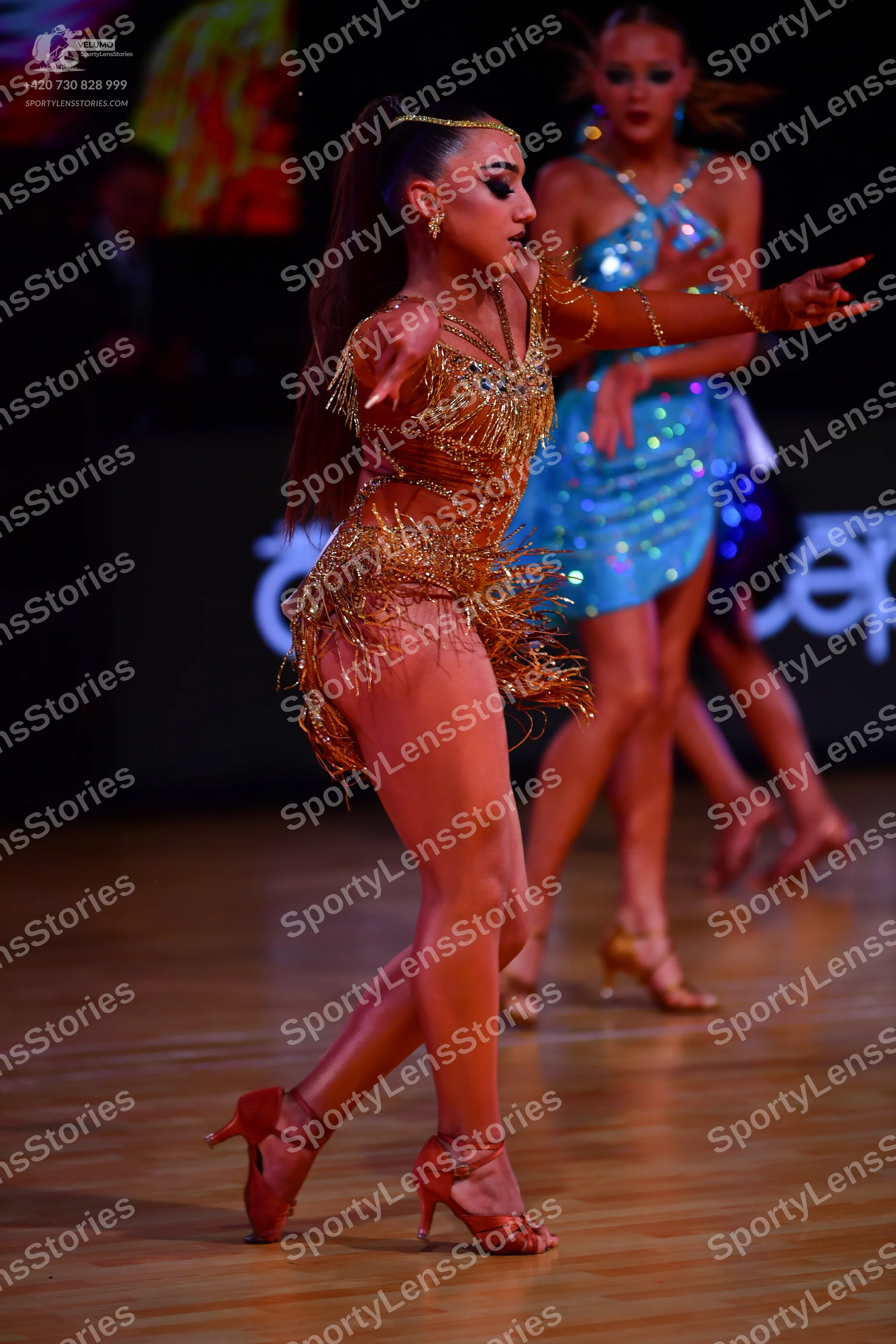 Dancesport competitor: Female dancer 1: gold/bronze latin dance costume with sequins, intricate beadwor