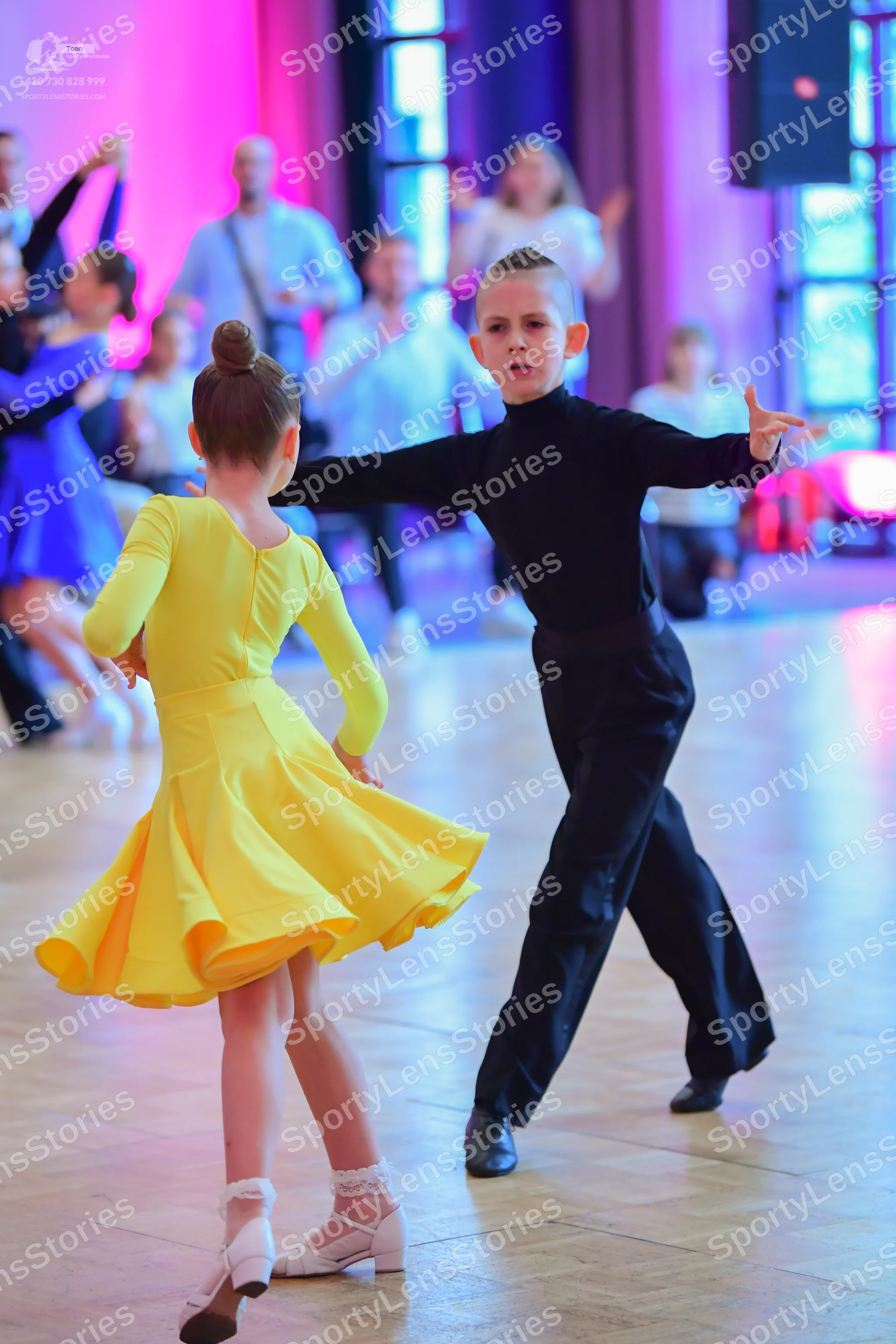 Dancesport competitor: Female dancer: yellow long-sleeved latin dress with a flared skirt and white dan