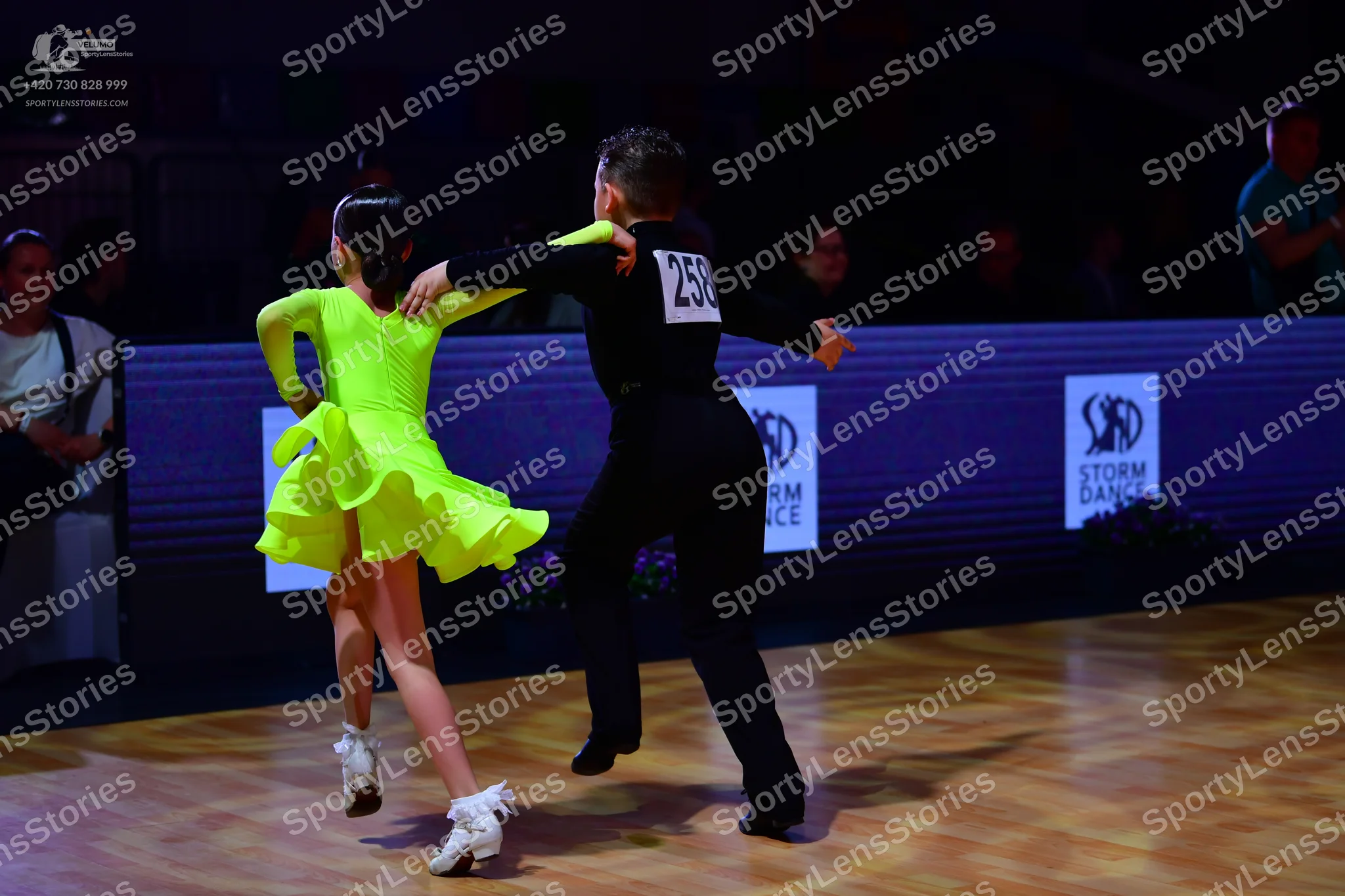 Dancesport competitor: Female dancer: lime green long-sleeved latin dance dress with a flared skirt