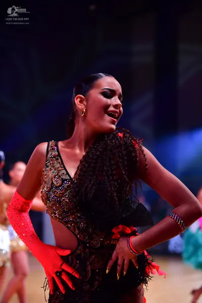 Dancesport competitor: Main female dancer: black latin dress with heavy gold and bronze sequin embellis