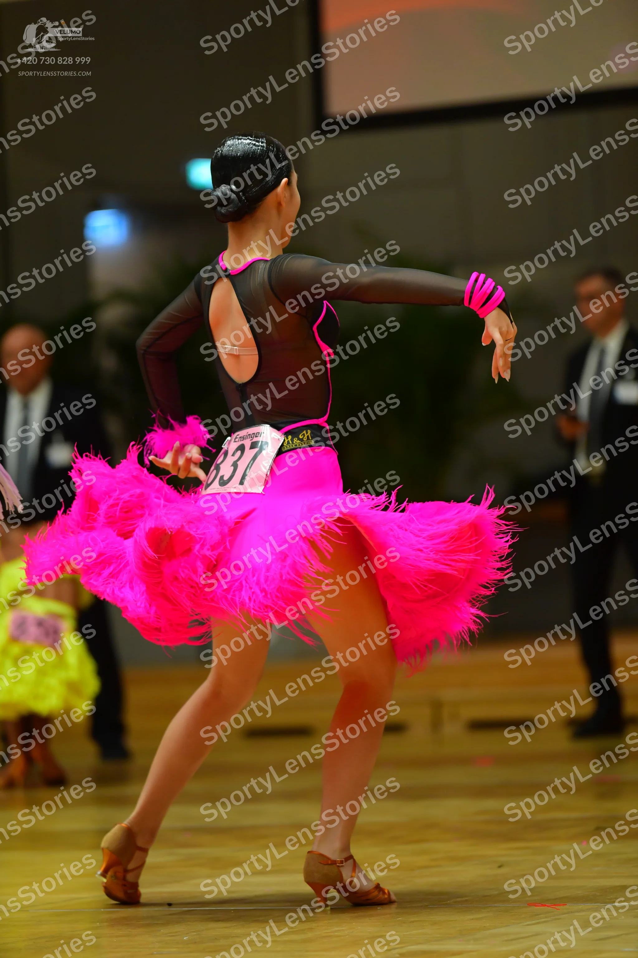 Dancesport competitor #337: Female dancer: black and pink Latin dance dress with mesh sleeves and fringe ski