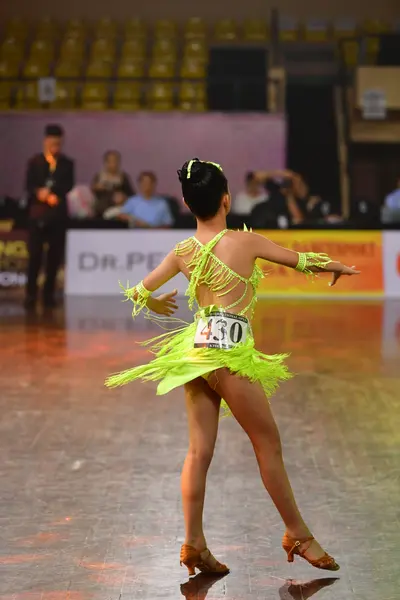 Dancesport competitor #430: Female dancer: bright lime green Latin dress with long fringe detailing on the s