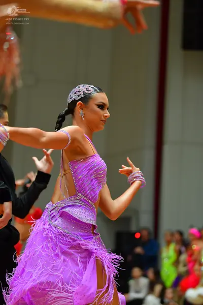 Dancesport competitor: Female dancer: lavender latin dance dress with a sequined bodice and feathered/f