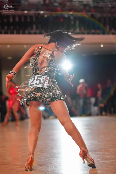 Dancesport competitor #25: Female dancer (foreground): black latin dress covered in large silver sequins wi