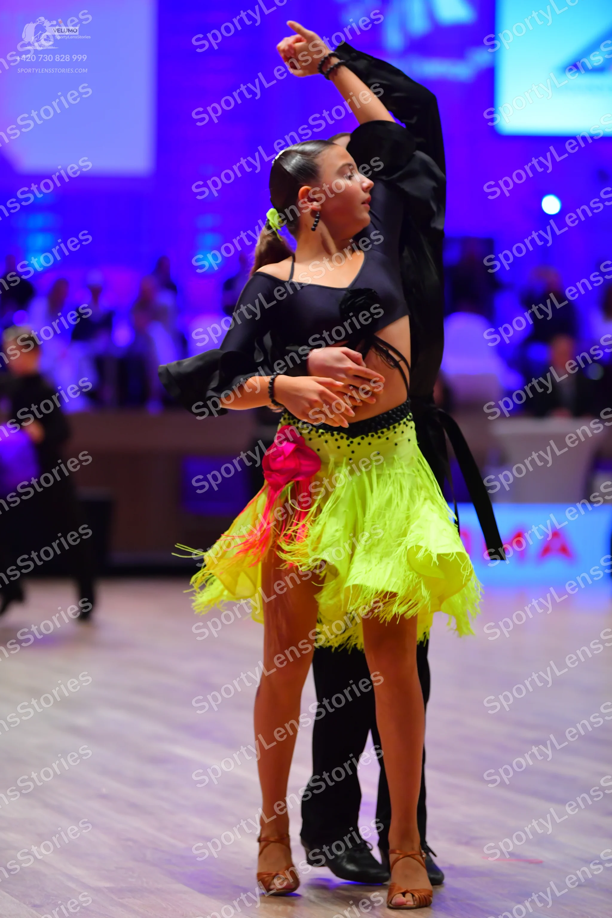 Dancesport competitor: Female dancer: black long-sleeved crop top with a black flower detail and a brig