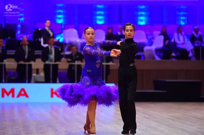 Dancesport competitor: Female dancer: blue Latin dance dress with patterned bodice and long sleeves, fe