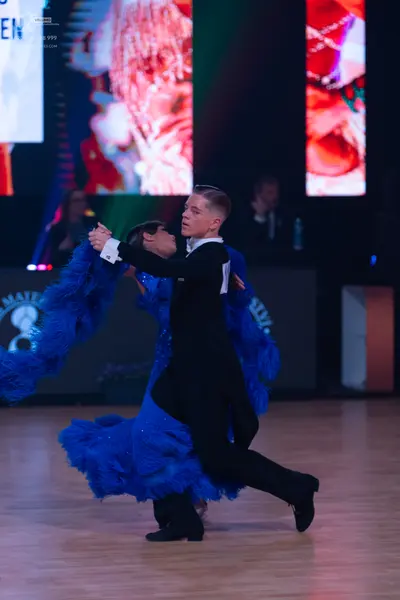 Dancesport competitor: Male dancer: black suit with a white shirt cuff