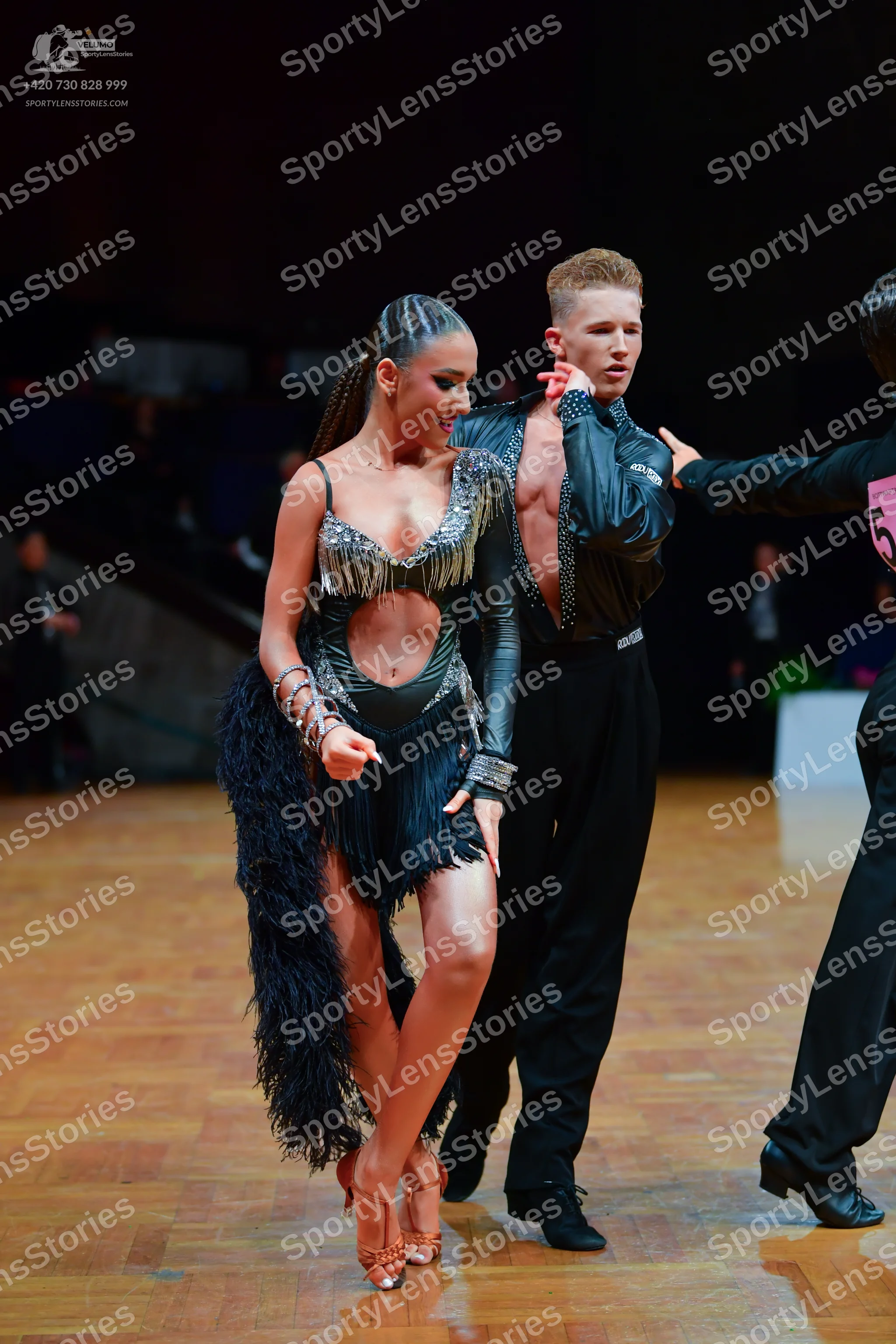 Dancesport competitor: Female dancer: black Latin dress with silver sequined/metallic trim on the bodic