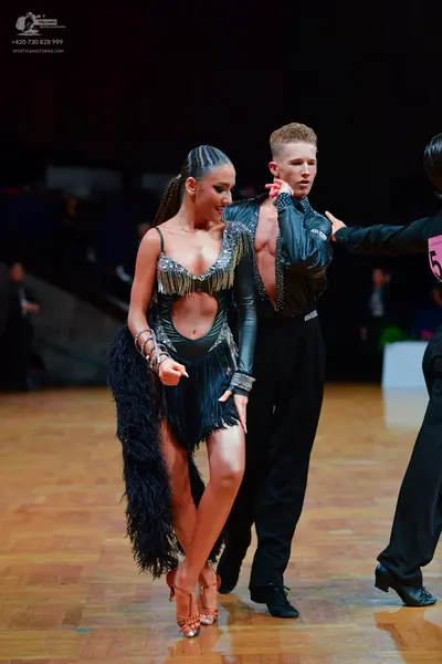 Dancesport competitor: Female dancer: black Latin dress with silver sequined/metallic trim on the bodic