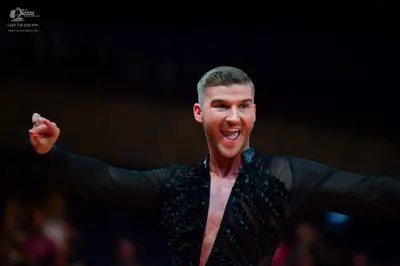 Dancesport competitor: Male dancer: black long-sleeved Latin dance top with textured black fabric detai