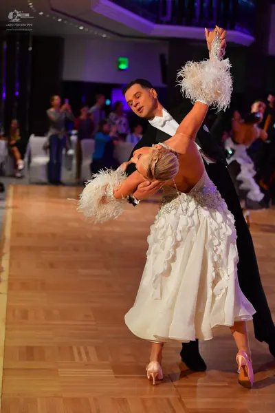 Dancesport competitor: Male dancer: black suit with a white shirt and white bow tie