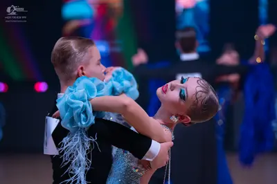 Dancesport competitor: Male dancer: black suit with white cuff and silver fringe