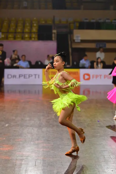 Dancesport competitor: Female dancer: lime green Latin dress with fringe