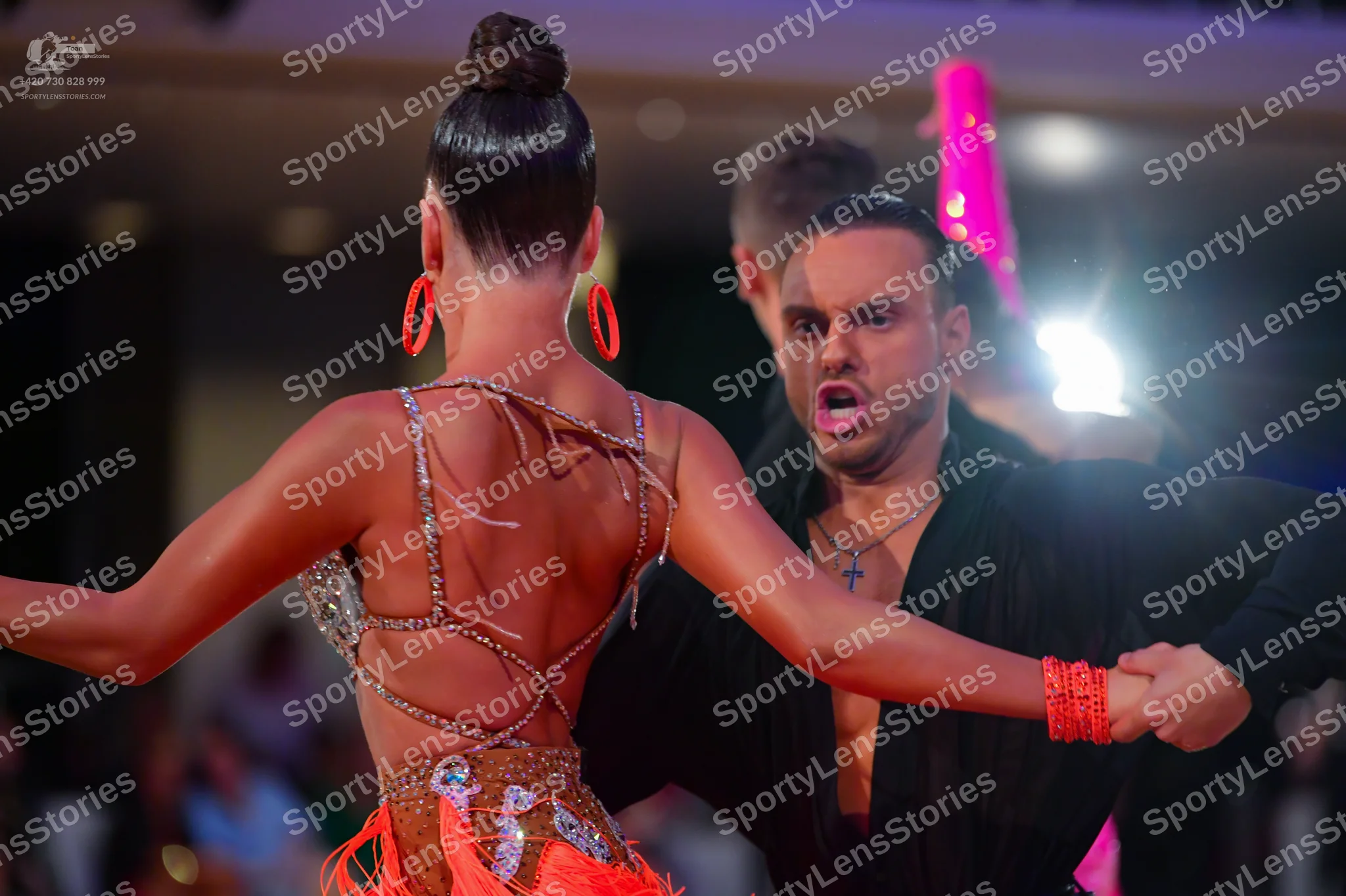 Dancesport competitor: Female dancer: orange Latin dress with thin sparkly straps and sequin embellishm