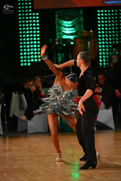 Dancesport competitor: Female dancer: silver sequined latin dress with ruffled, layered fabric and spar