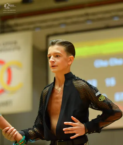 Dancesport competitor: Male dancer: black latin dance shirt with mesh sleeves and an open front, accomp