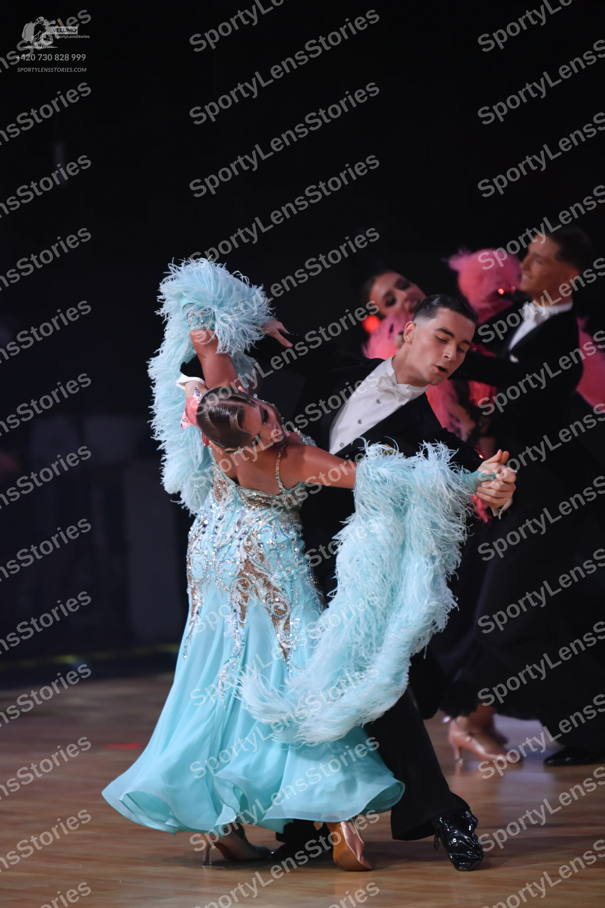 Dancesport competitor: Female dancer (foreground): light blue ballgown with a sequined and beaded bodic