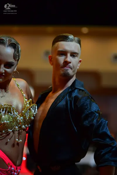Dancesport competitor: Female dancer: gold embellished bra-style top with pearls and sequins, paired wi